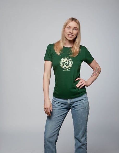 Mujer con camiseta verde de algodón con mensaje "Save the Planet" y vaqueros azules.