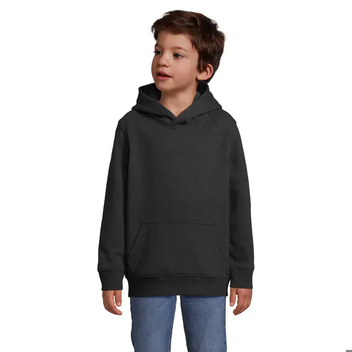 Niño con sudadera negra con capucha y bolsillo frontal, combinado con pantalones vaqueros azules.