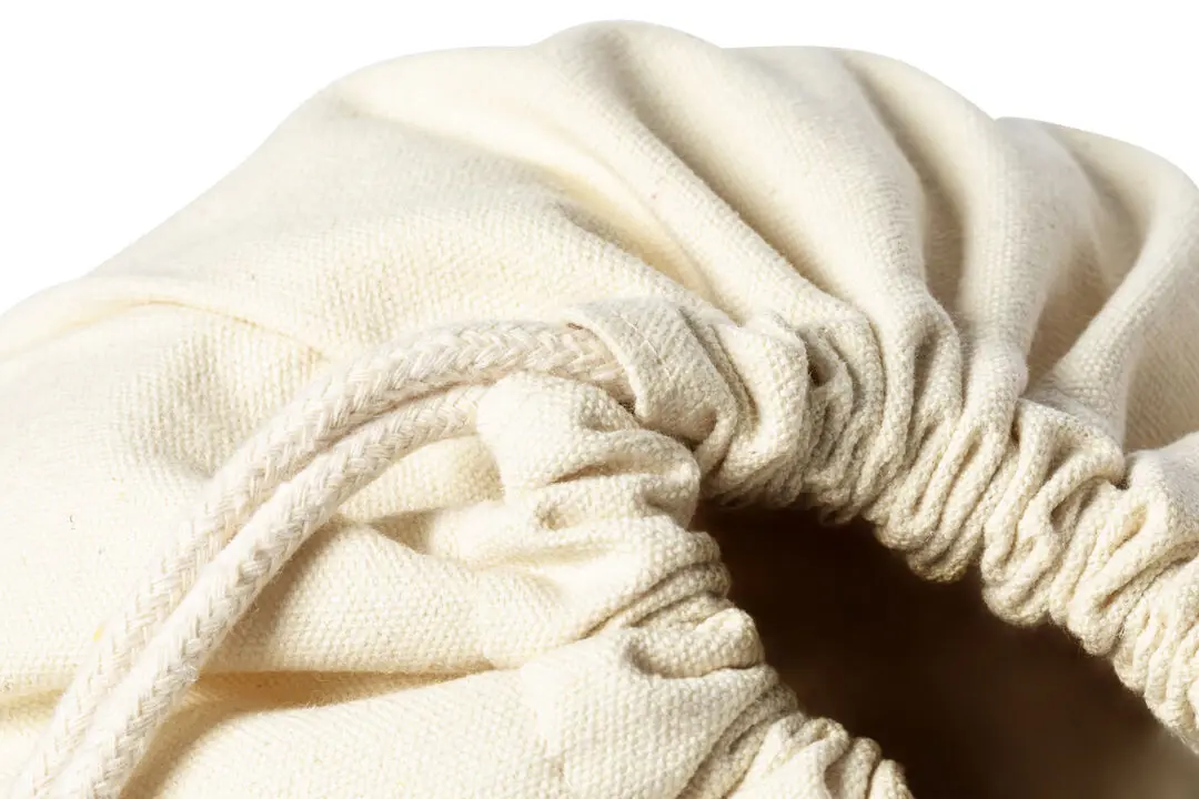 Bolsa de tela beige con cierre de cordón para almacenamiento.