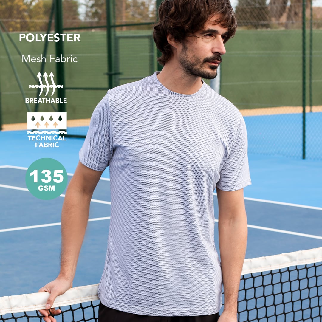 Hombre con camiseta técnica de poliéster transpirable de malla gris claro en pista de tenis.