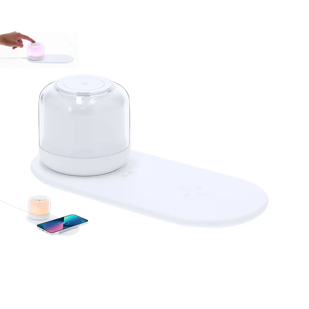 Estación blanca de carga inalámbrica con lámpara LED táctil y difusor aromático junto a un smartphone cargándose