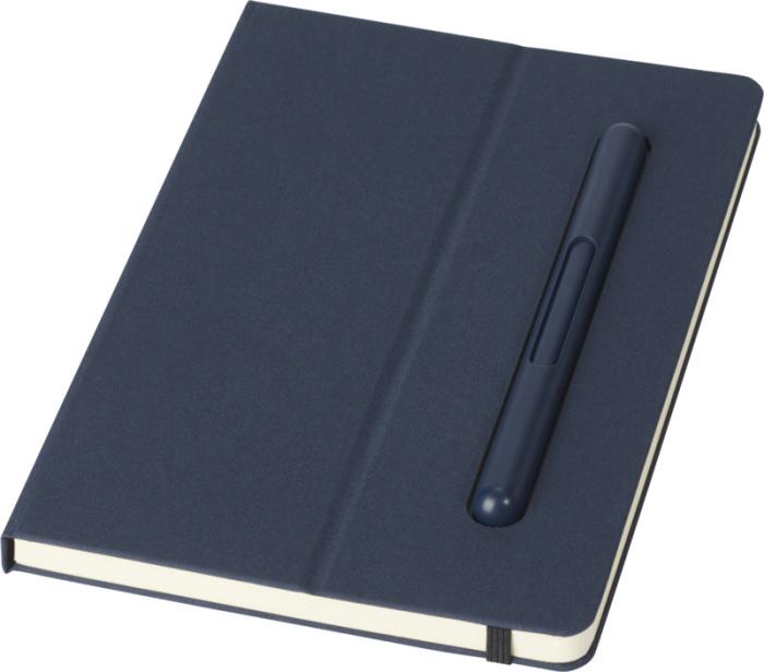 Cuaderno azul marino de tapa dura con bolígrafo encajado en la cubierta