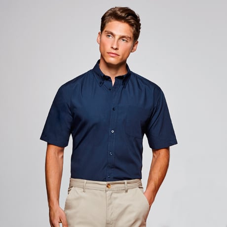 Camisa azul marino de manga corta con cuello abotonado y bolsillo en el pecho.