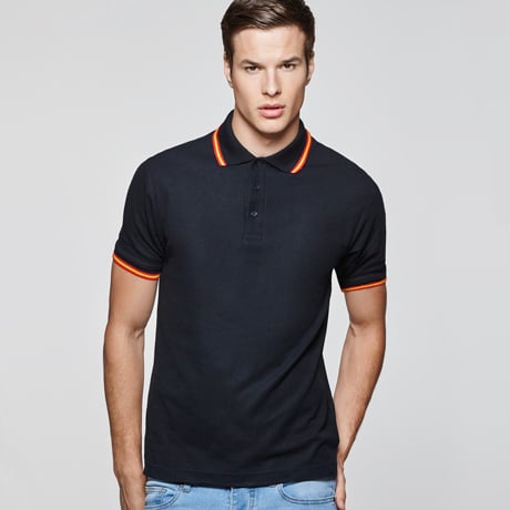 Polo negro de manga corta con detalles naranjas en cuello y puños, combinado con vaqueros claros.