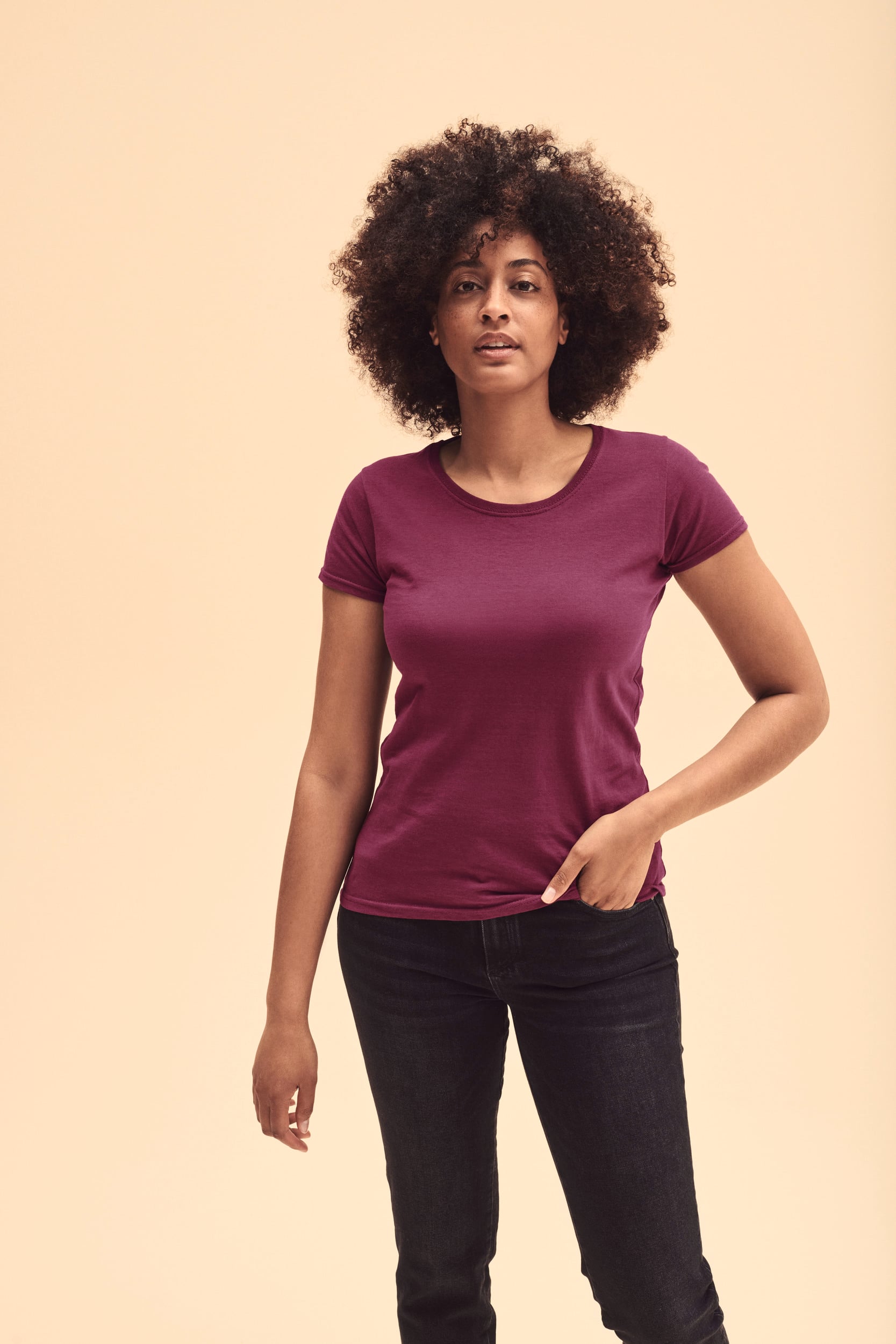 Mujer con camiseta básica de algodón color burdeos y pantalones vaqueros negros.